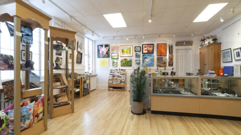 Image de la boutique au CCMF, vue de face du comptoir et des œuvres au murs