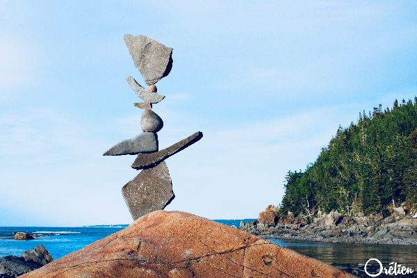 Photographie d'équilibre de roches au bord d'un lac